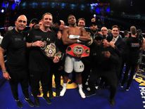 Joshua celebrates with his team following his victory